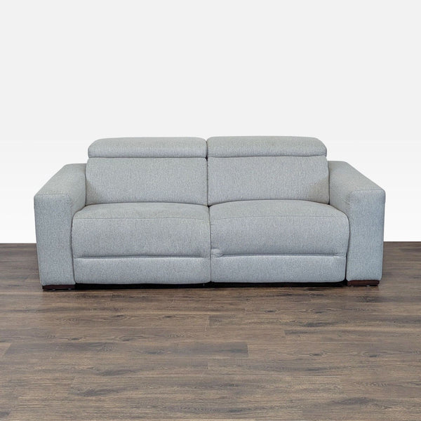 1. Light gray Macy’s sofa with wide arms, adjustable headrests, and a modern design displayed on wood flooring.