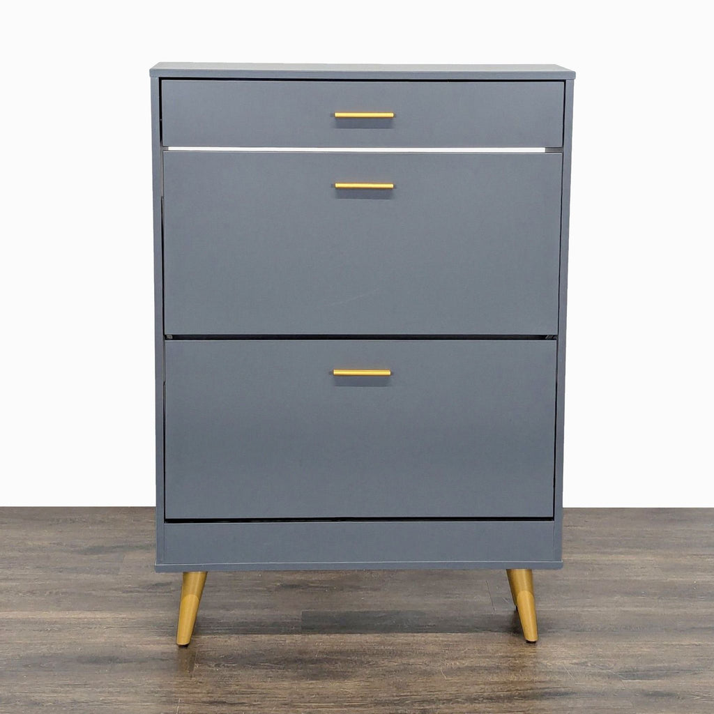 1. Everly Quinn gray cabinet with gold handles and legs, featuring a modern, minimalist design on wood flooring.
