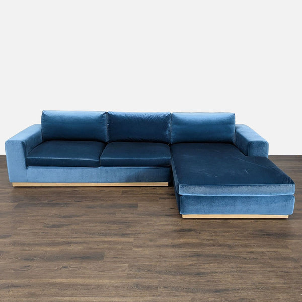 1. Modern blue velvet Rove Concepts sectional with light wood base and spacious chaise, shown from the front.