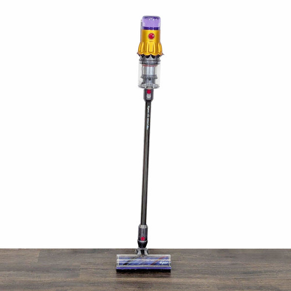 Dyson cordless stick vacuum cleaner standing upright, lightweight design for easy use on floors and carpets.  