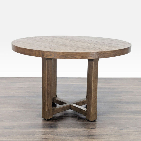 1. Round Restoration Hardware dining table in oak veneer with visible wood grain and a sturdy cross-base design.