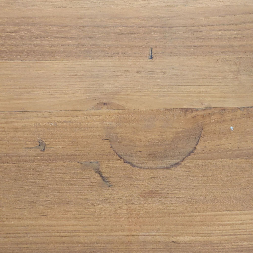 2. Close-up of the coffee table's teak wood surface, highlighting a circular stain and natural wood grain.  