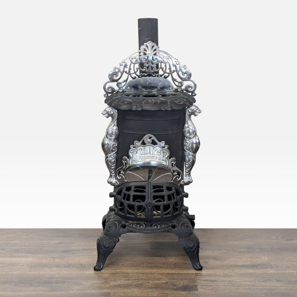 1. Front view of a vintage cast iron parlor stove by Reperch, with nickel accents and ornate grillwork.