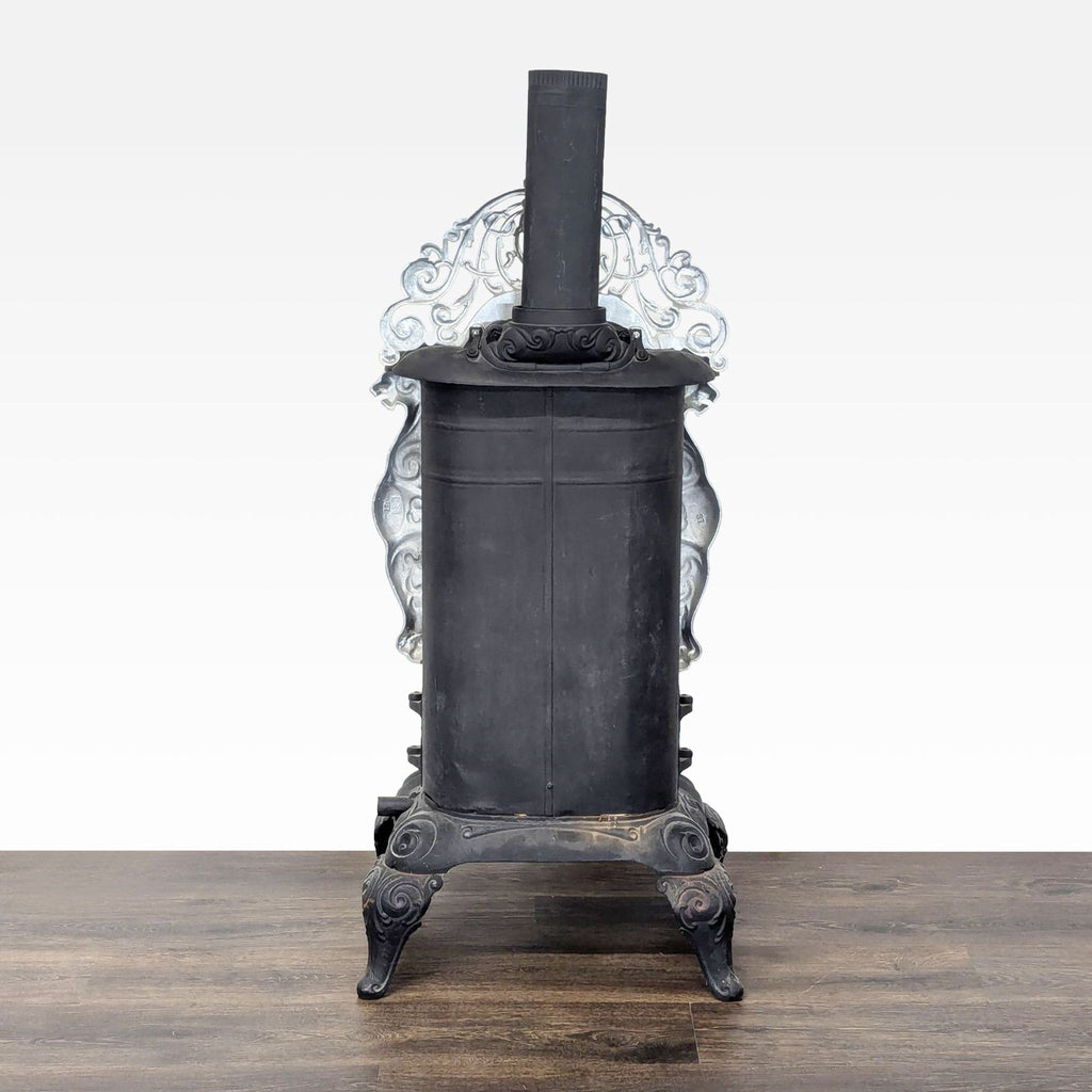 2. Rear view of the Reperch vintage parlor stove, showing its cylindrical cast iron body and decorative elements.