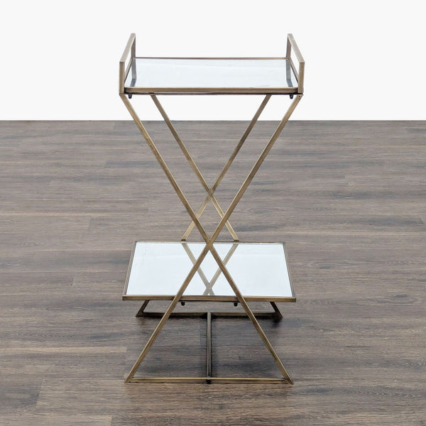 1. Reperch side table with gold metal frame, two glass shelves, and X-shaped support on wood flooring.