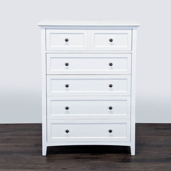 1. White Modus dresser with five drawers and black knobs, shown on a dark wood floor, front view.