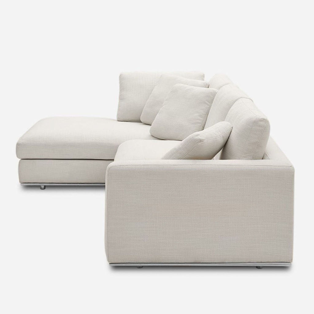 2. Side view of a modern light beige Castlery sectional with deep cushions and a wide chaise for comfort.  