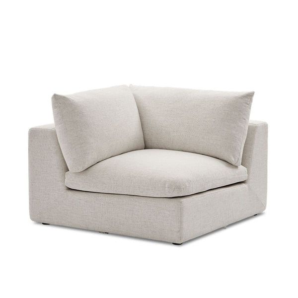 Castlery corner section seat in light beige fabric with wide cushioned seat and plush back pillows, modern style.  