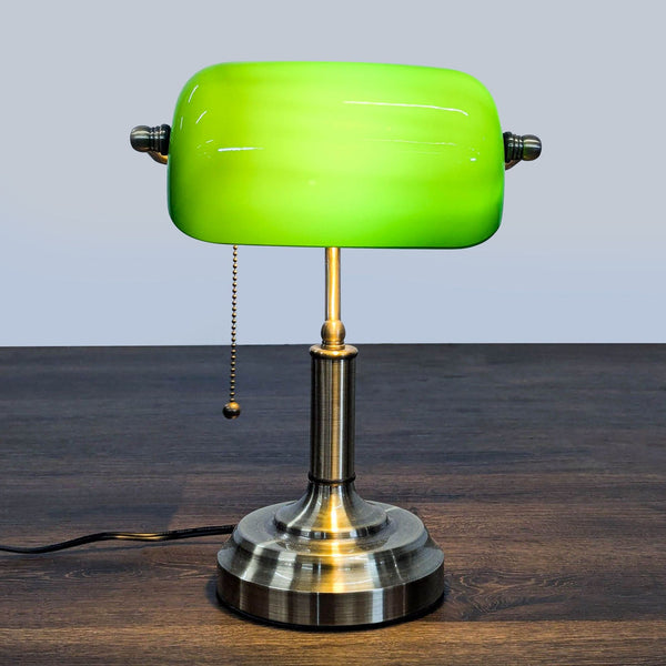 Green glass-shaded TorchStar desk lamp with brass base and pull chain, ideal for desks or offices.  