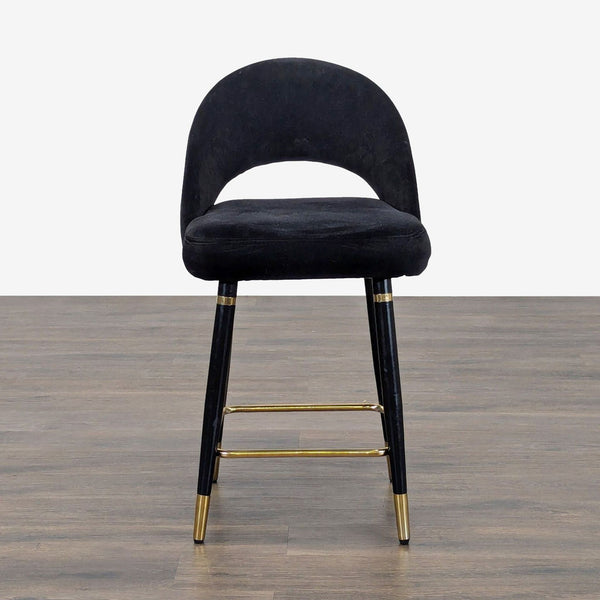 Stool featuring metal legs, brass finish footrest, and trim, ideal for seating or accent use.  