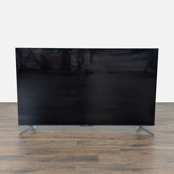 1. Front view of a TCL 65" 4K UHD Smart TV with a slim, modern design and stable dual-leg stand.