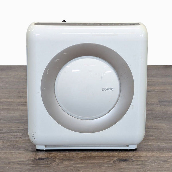 1. Front view of a compact white Coway air purifier with minor scratches, ideal for improving indoor air quality.