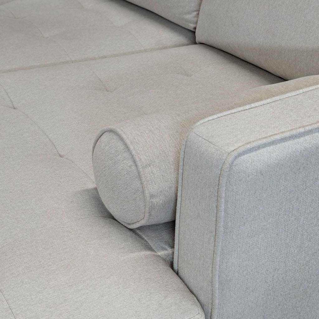 3. Close-up of the Living Spaces sectional’s tufted seat and cylindrical pillow, showing fabric and stitching details.