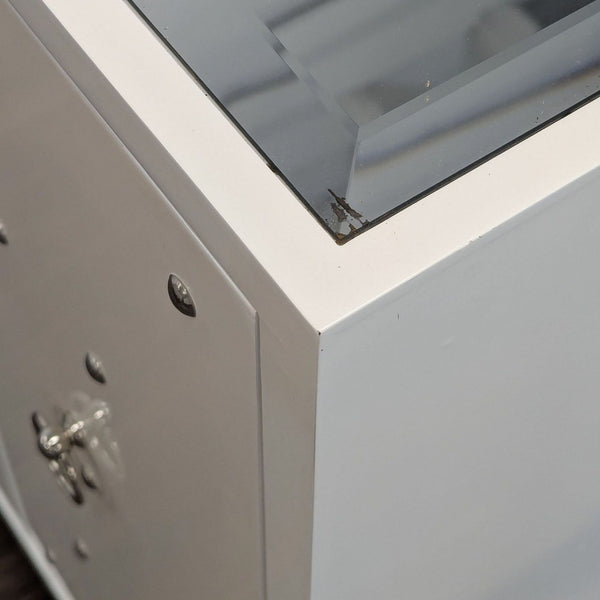 1. Close-up of the Reperch sideboard’s corner, showing a white surface with a glass top and minor wear.  