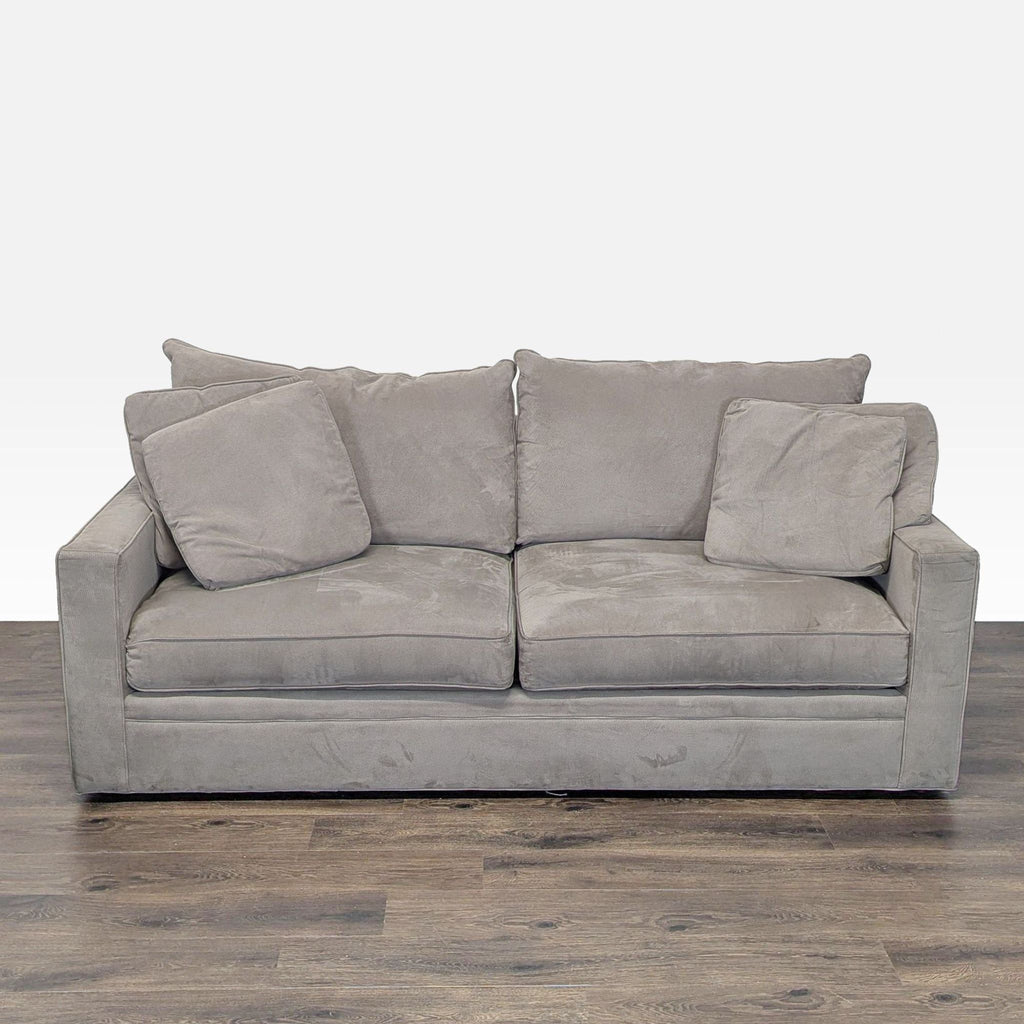 1. Front view of a modern Room & Board gray sleeper sofa with plush back and seat cushions on wood flooring.