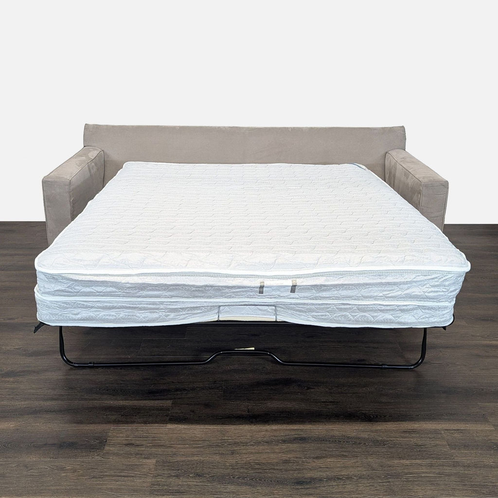 2. Room & Board gray sleeper sofa transformed into a bed with a pull-out air coil mattress for guests.