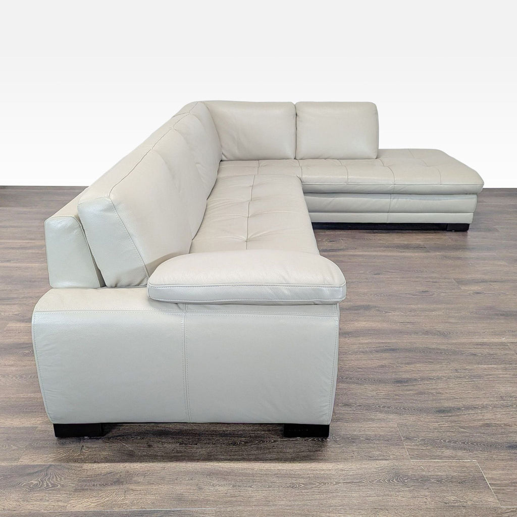 Side view of a spacious, light gray leather sectional by Scandinavian Designs with supportive seating and sleek lines.