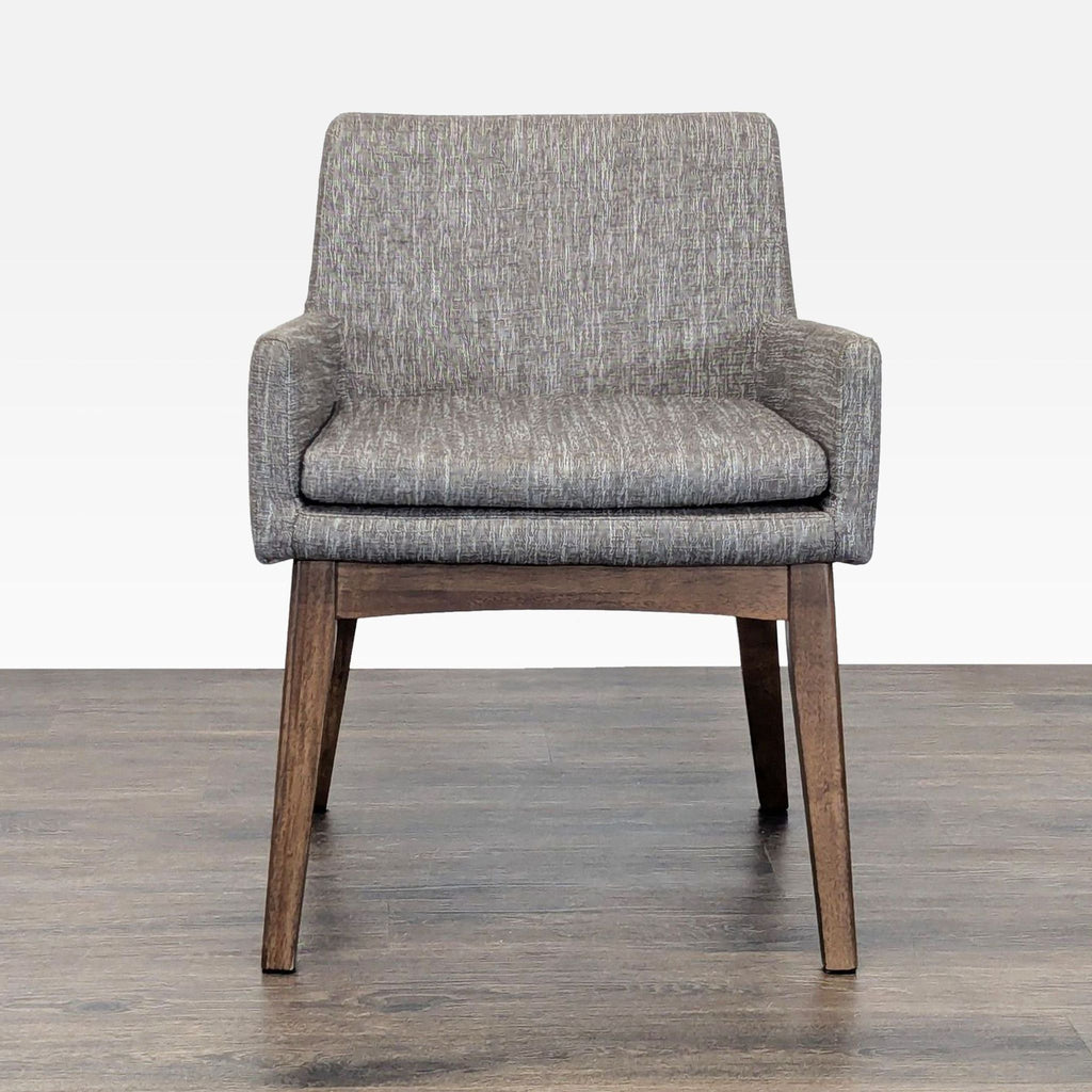 Front view of a modern Article lounge chair with grey upholstery and sturdy wooden legs, ideal for relaxing spaces.