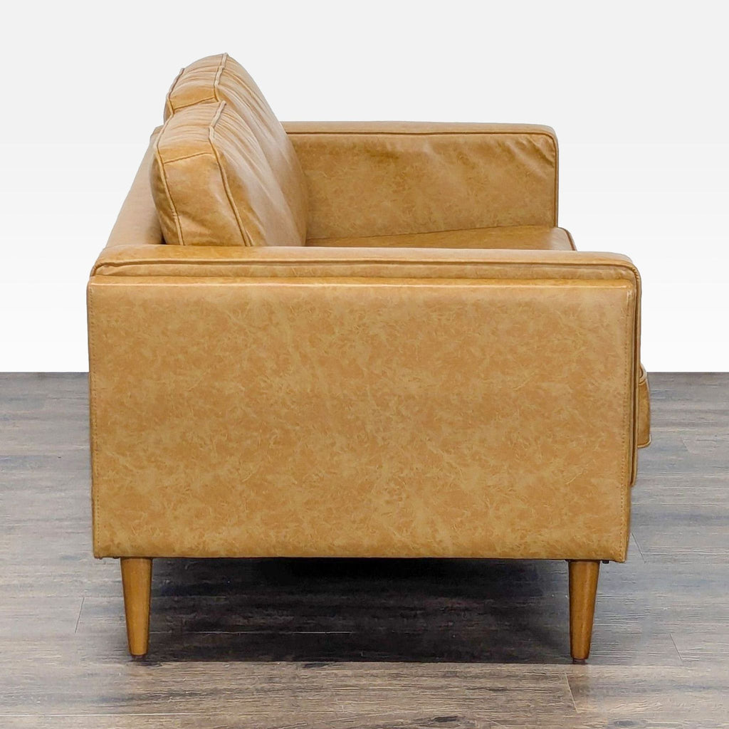 2. Side view of a compact Albany Park loveseat, showing tan vegan leather upholstery and sleek arm design.