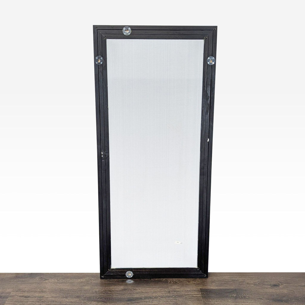2. Back of Ikea wood-framed mirror with metal mounting hardware, displayed on a dark wooden floor.  