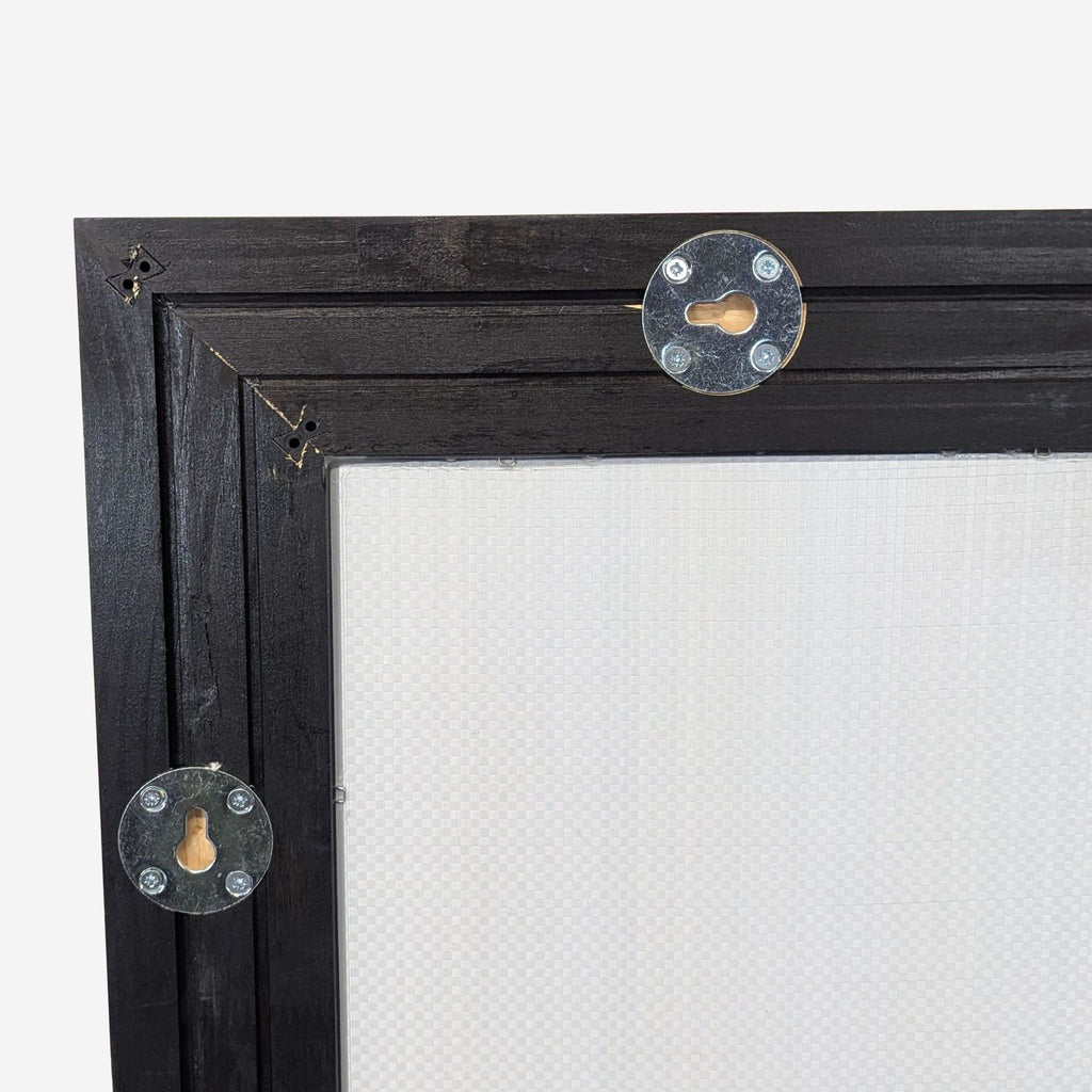 3. Close-up of upper back corner of Ikea wood-framed mirror, highlighting metal keyhole mounting plates.