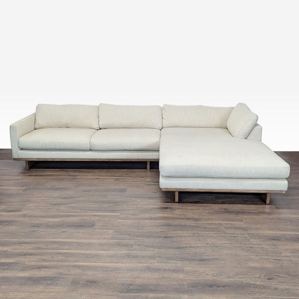 1. Reperch sectional in light beige fabric with modern lines, wood base, and spacious chaise for lounging.