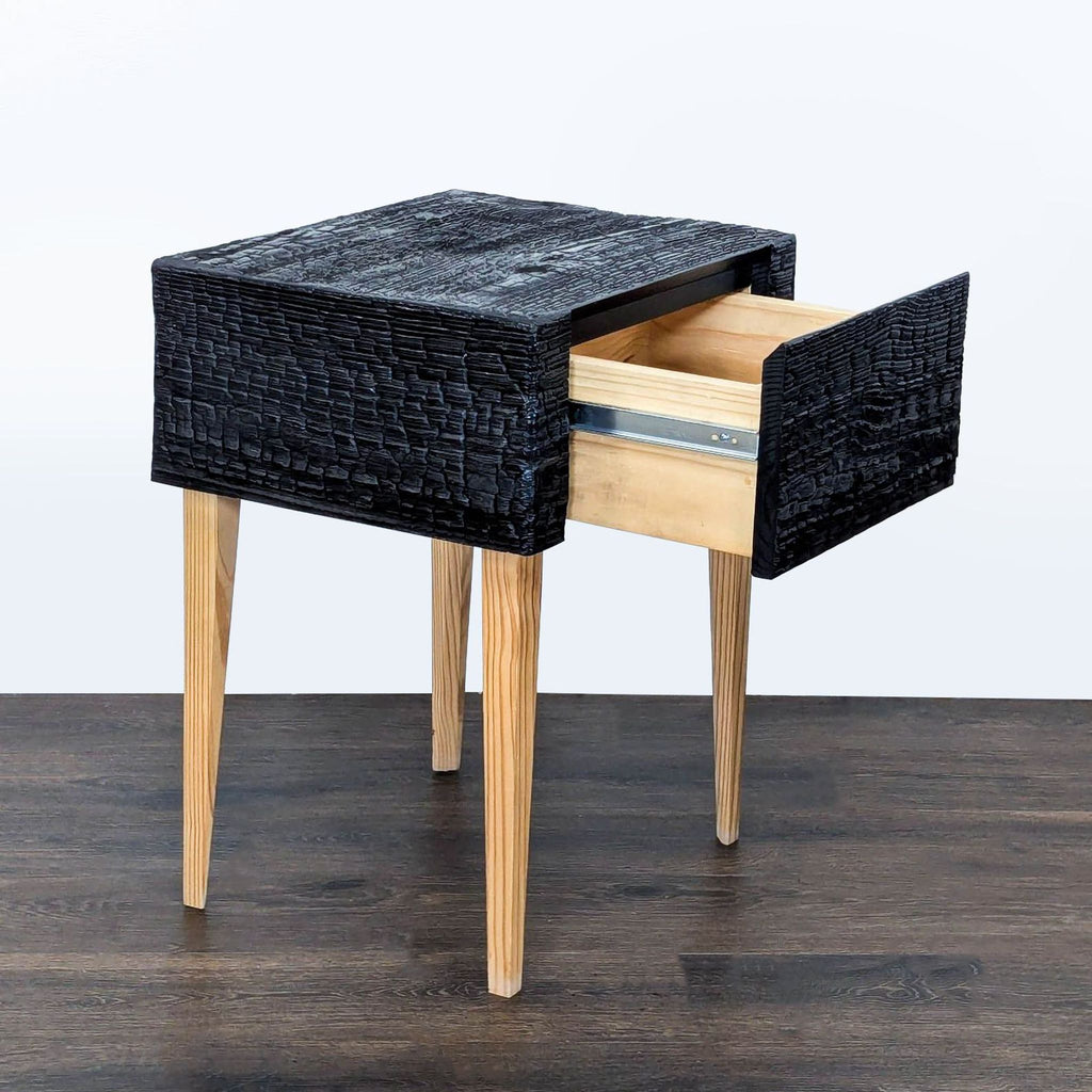 Side view of a Reperch end table showing a single drawer open, with textured charred wood contrasting pine.