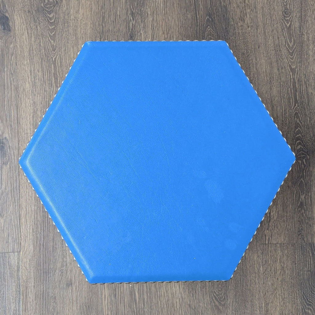 Overhead close-up of the hexagonal blue leather stool by Wisteria, highlighting the nickel stud edges.