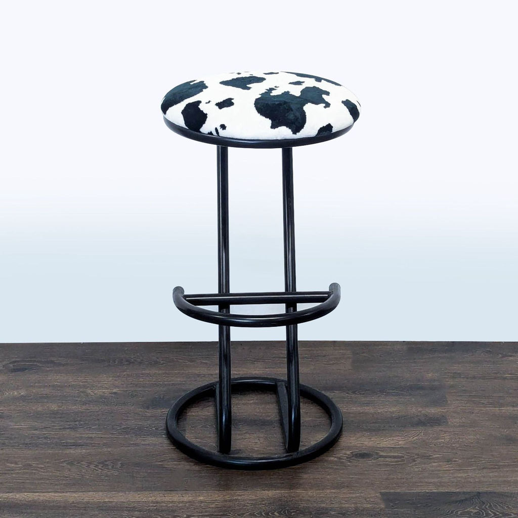 1. Modern Reperch stool with cow print seat and black metal frame, shown on a dark wooden floor.
