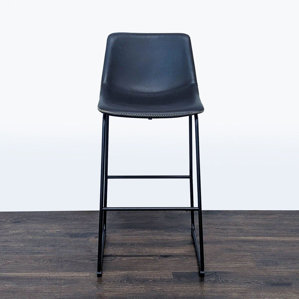 1. Modern black bar stool with a metal frame from Living Spaces, shown from the front on a wooden floor.