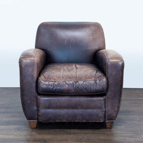 1. Restoration Hardware lounge chair in brown leather with worn, vintage style, wide seat, and wooden legs.