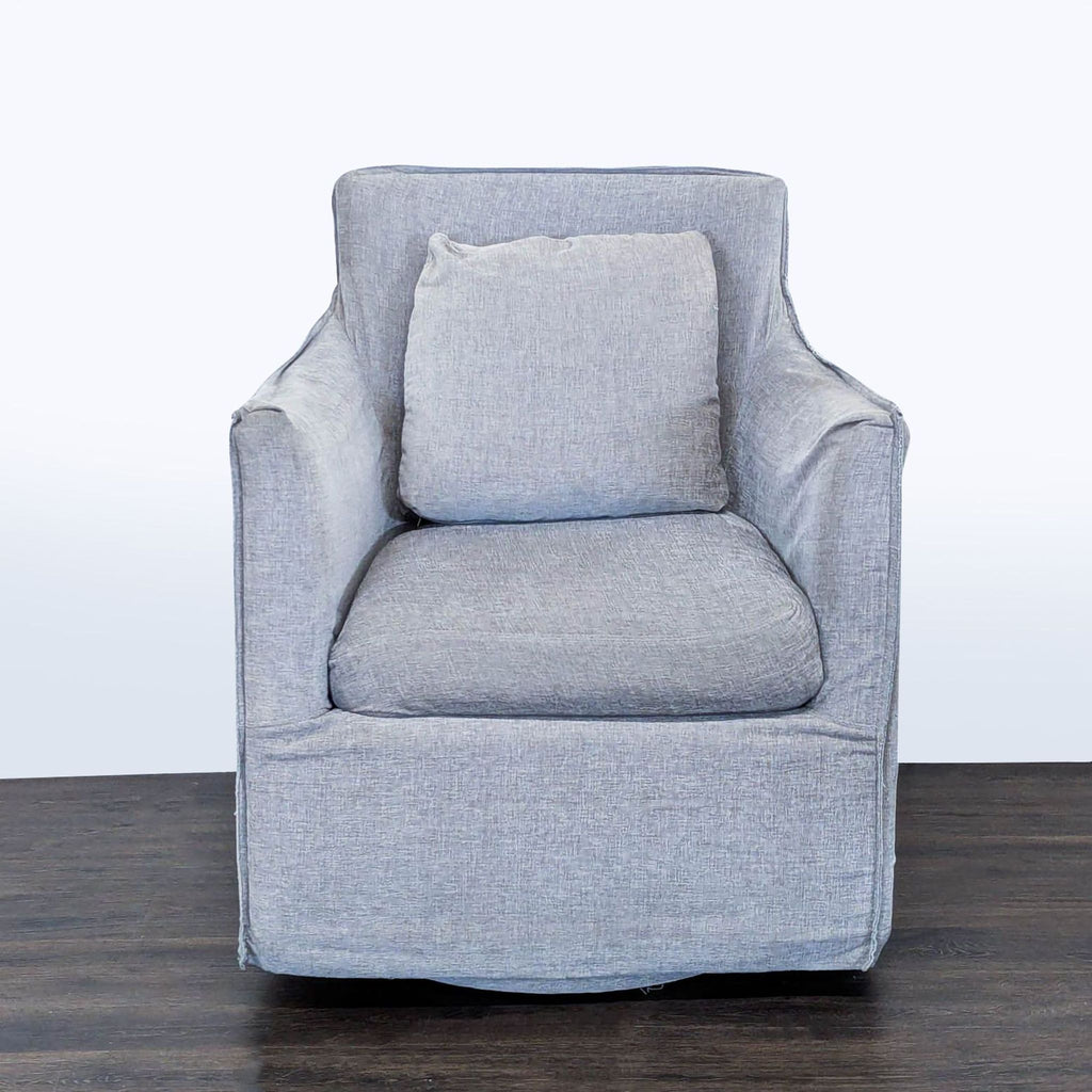 1. Front view of a gray upholstered lounge chair with a cushion, by Restoration Hardware, on a wooden floor.