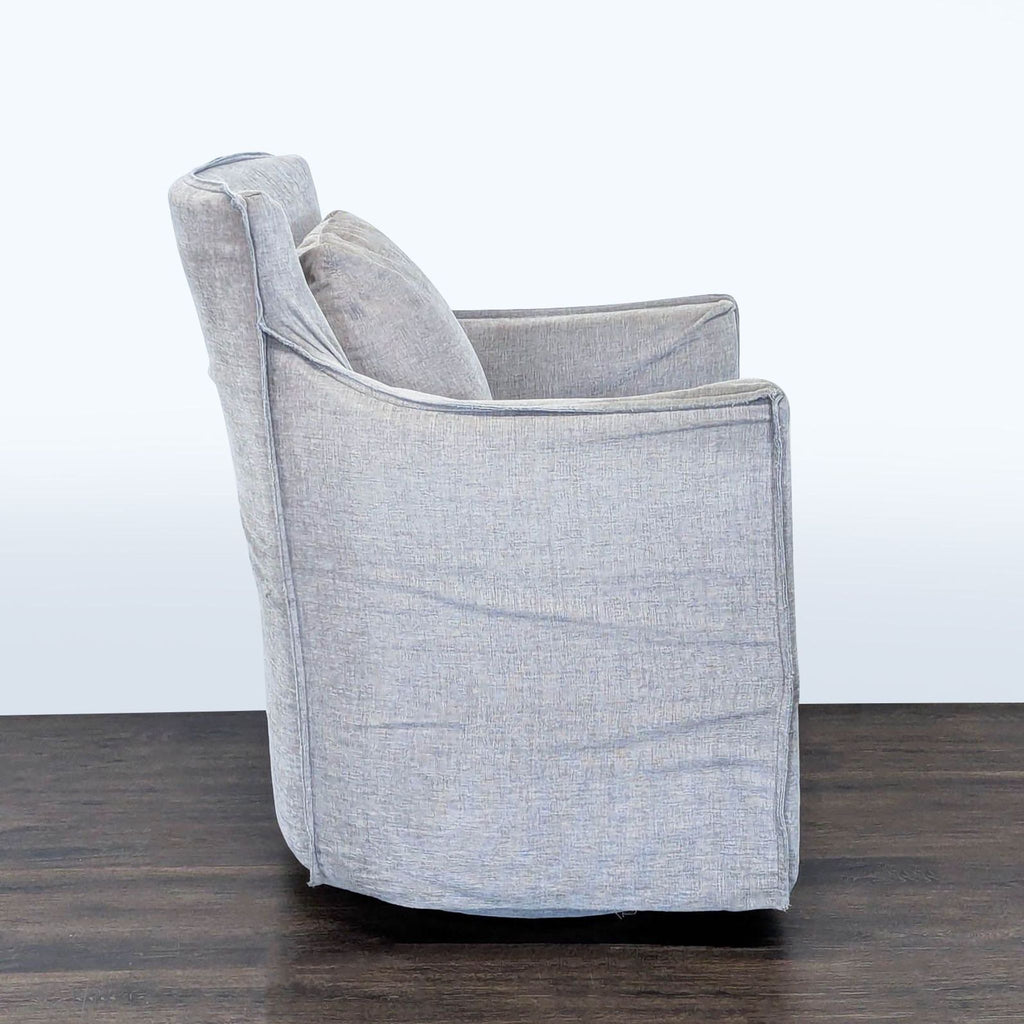 3. Side profile of a Restoration Hardware lounge chair, shown with light gray fabric and comfortable padding.