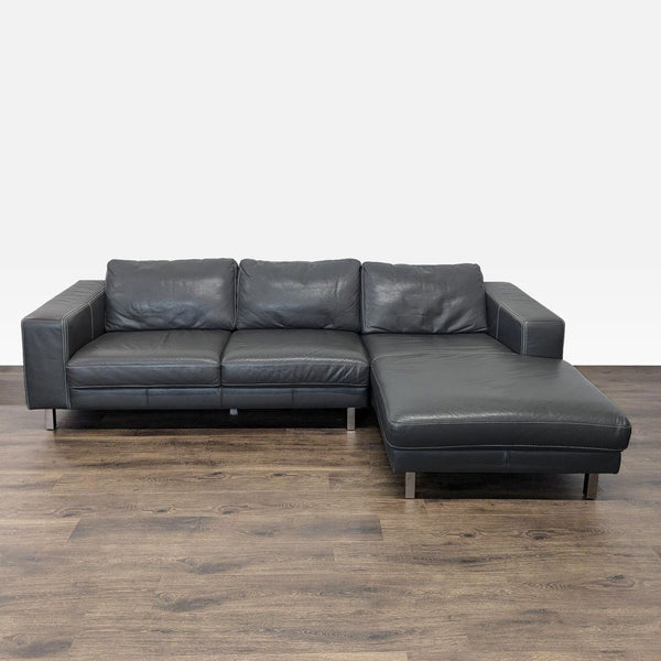Modern leather sectional with right-side chaise, wide arms, metal legs, and spacious, plush seating.