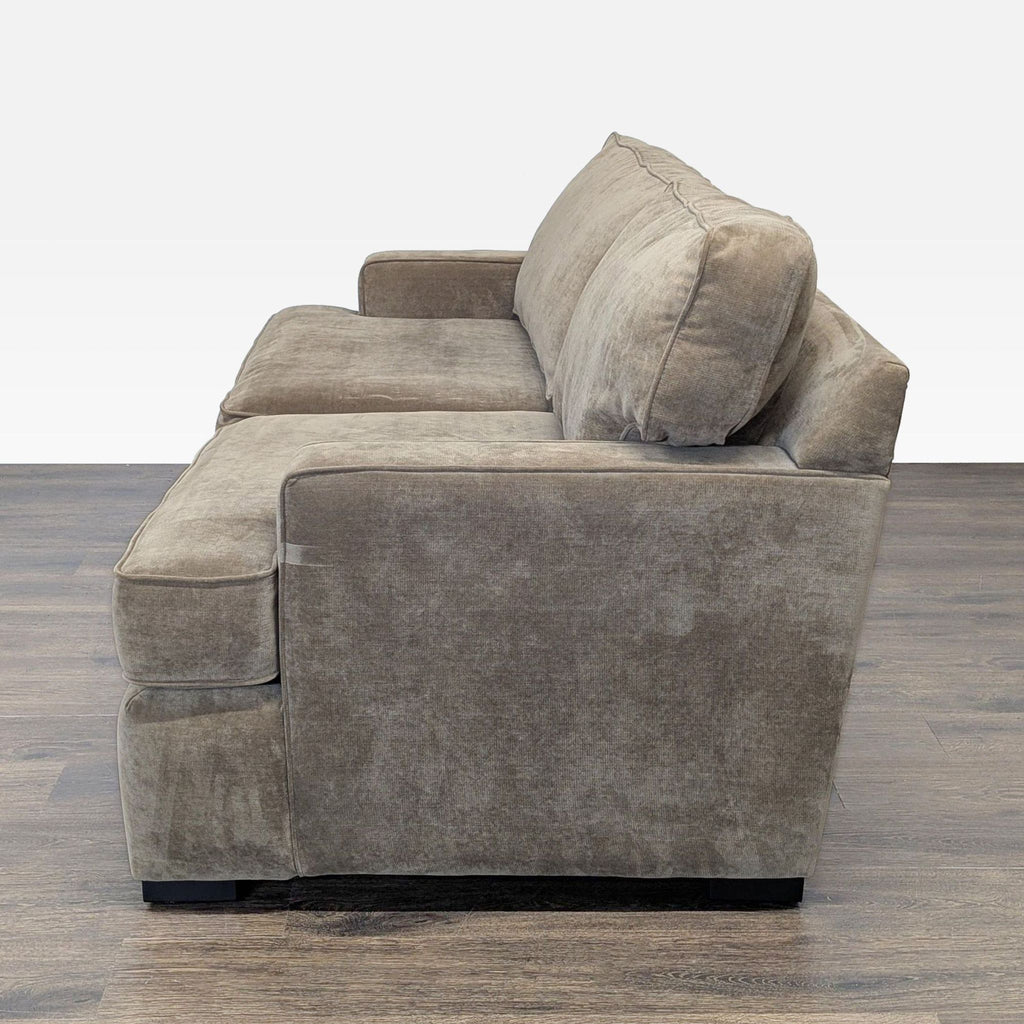 1. Side view of a Reperch sleeper sofa with plush cushions and armrests, set on a wood floor.  
