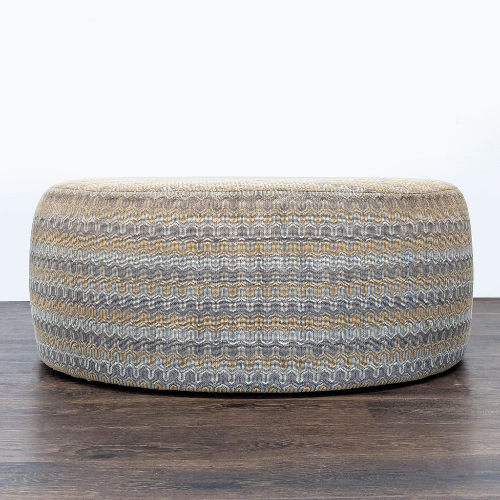 Patterned round ottoman in muted colors from Room & Board, shown from multiple angles on wood flooring.