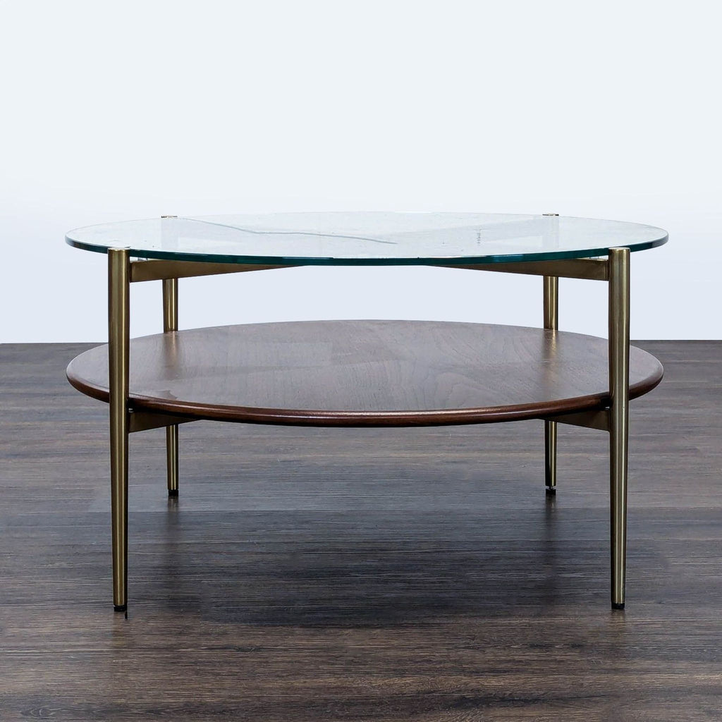 1. Round Williams Sonoma coffee table with a glass top, brass legs, and a lower wood shelf on dark flooring.  