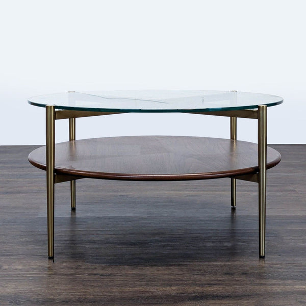 1. Round Williams Sonoma coffee table with a glass top, brass legs, and a lower wood shelf on dark flooring.  