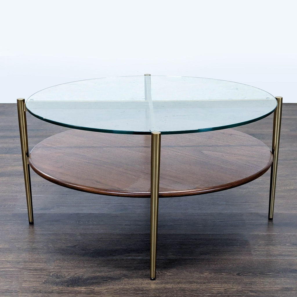 2. Modern coffee table by Williams Sonoma featuring a round glass top, wooden lower shelf, and gold-toned frame.  