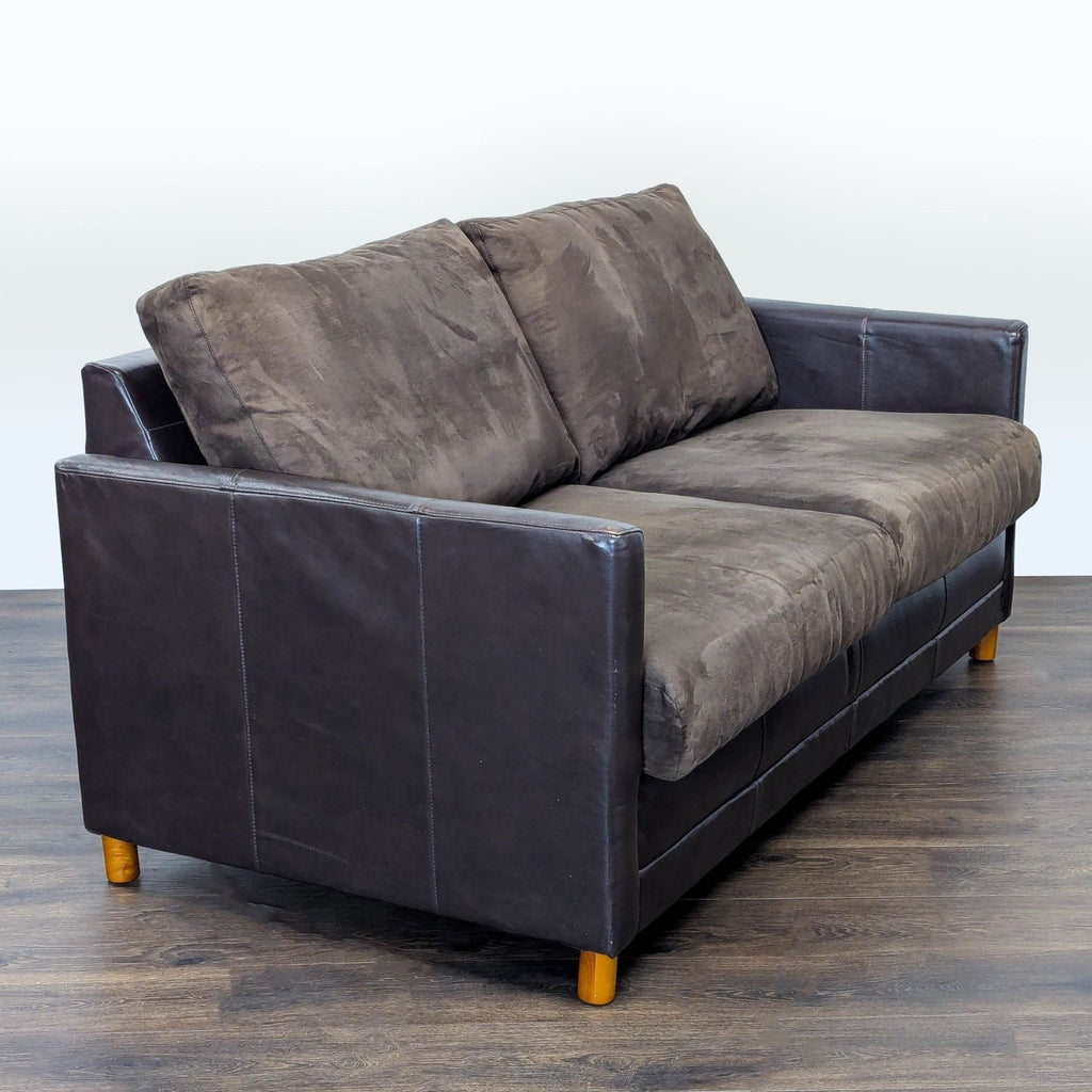 2. Angled side view of Reperch Sleeper Sofa showing soft brown cushions and sleek, dark leather sides.