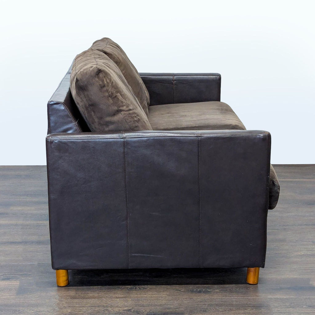 3. Side profile of the Reperch Sleeper Sofa with brown cushion seating and dark arms on wood legs.