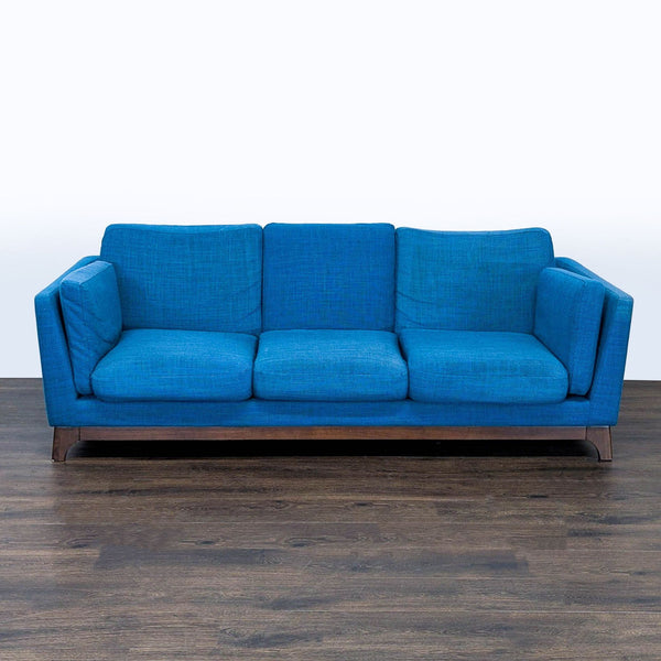 1. Article brand 3-seat sofa in vibrant blue fabric with wooden base, viewed from the front on a wooden floor.  