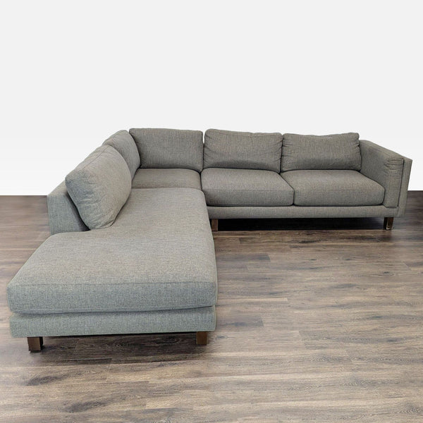 Modern Room & Board sectional with a chaise lounge, neutral fabric upholstery, and plush cushions for comfort.
