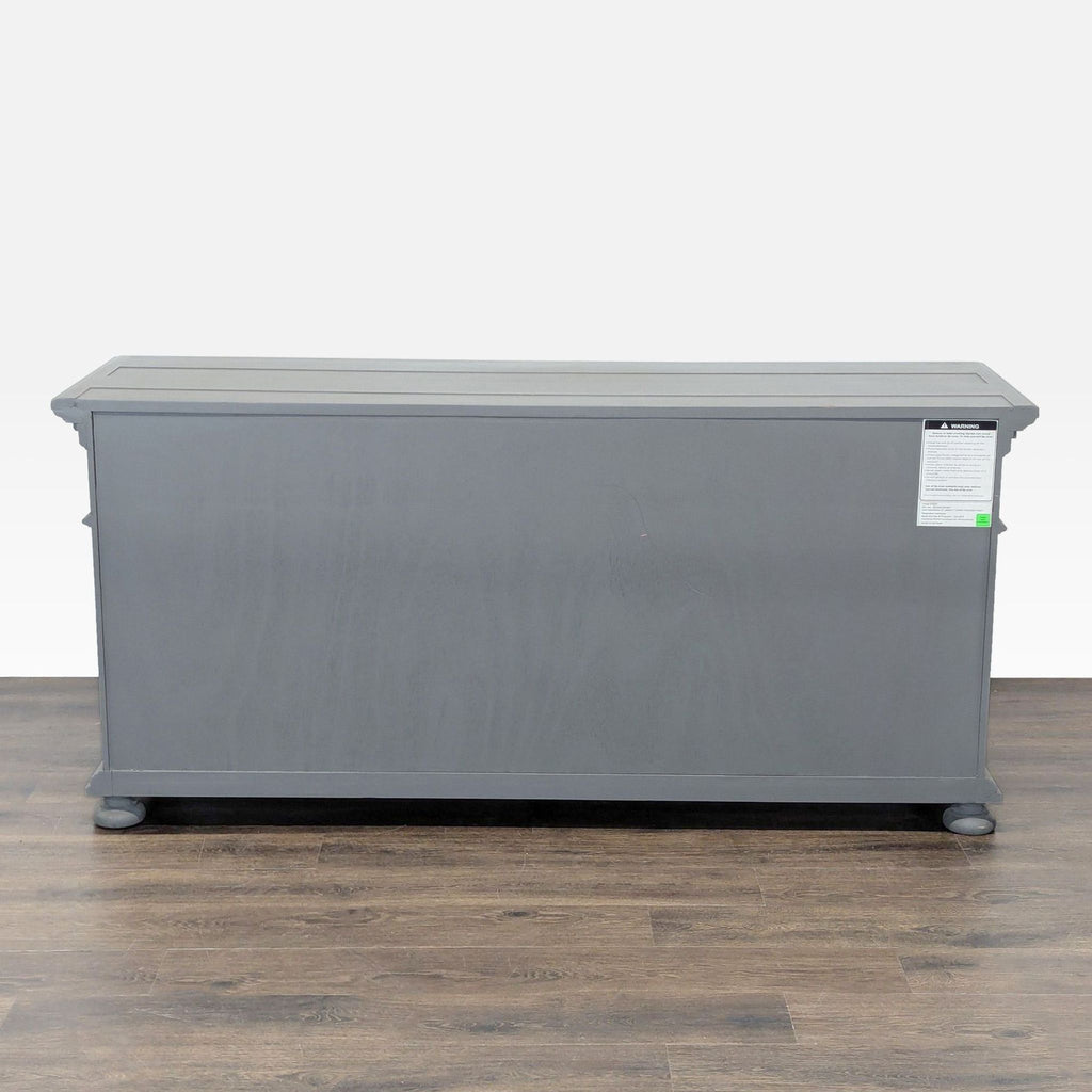 1. Gray Restoration Hardware dresser viewed from the back, showcasing a simple rectangular design and wooden legs.