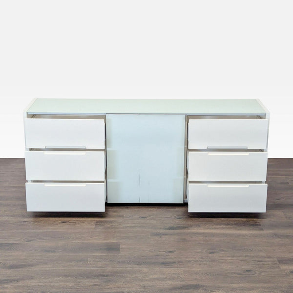 Sleek white dresser with six drawers, glass shelves, and a cabinet, ideal for modern room storage.
