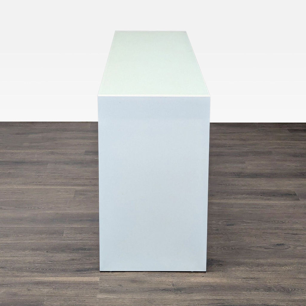 2. Side view of a minimalist white Reperch dresser with a simple, solid rectangular design and smooth surface.