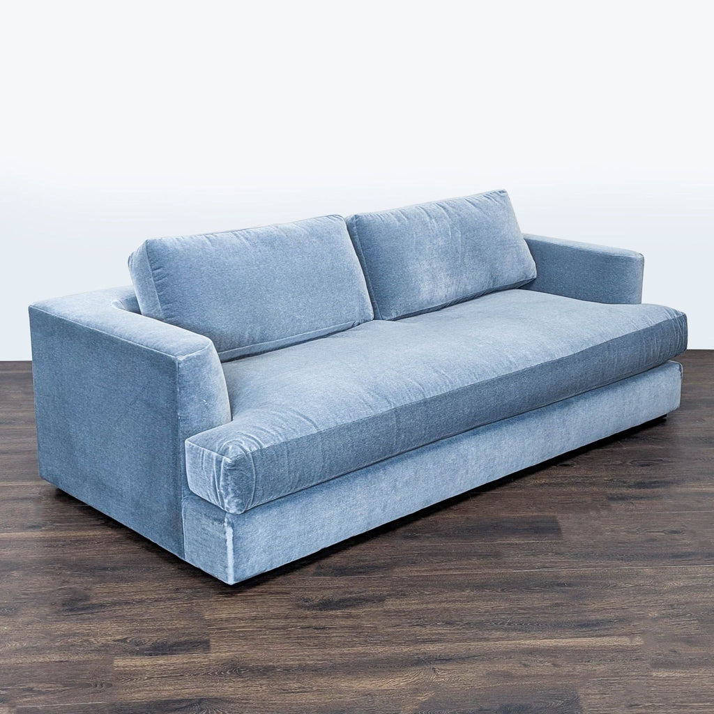 2. Angled view of a Maiden Home 3-seat sofa in soft blue fabric with wide arms and deep seat.