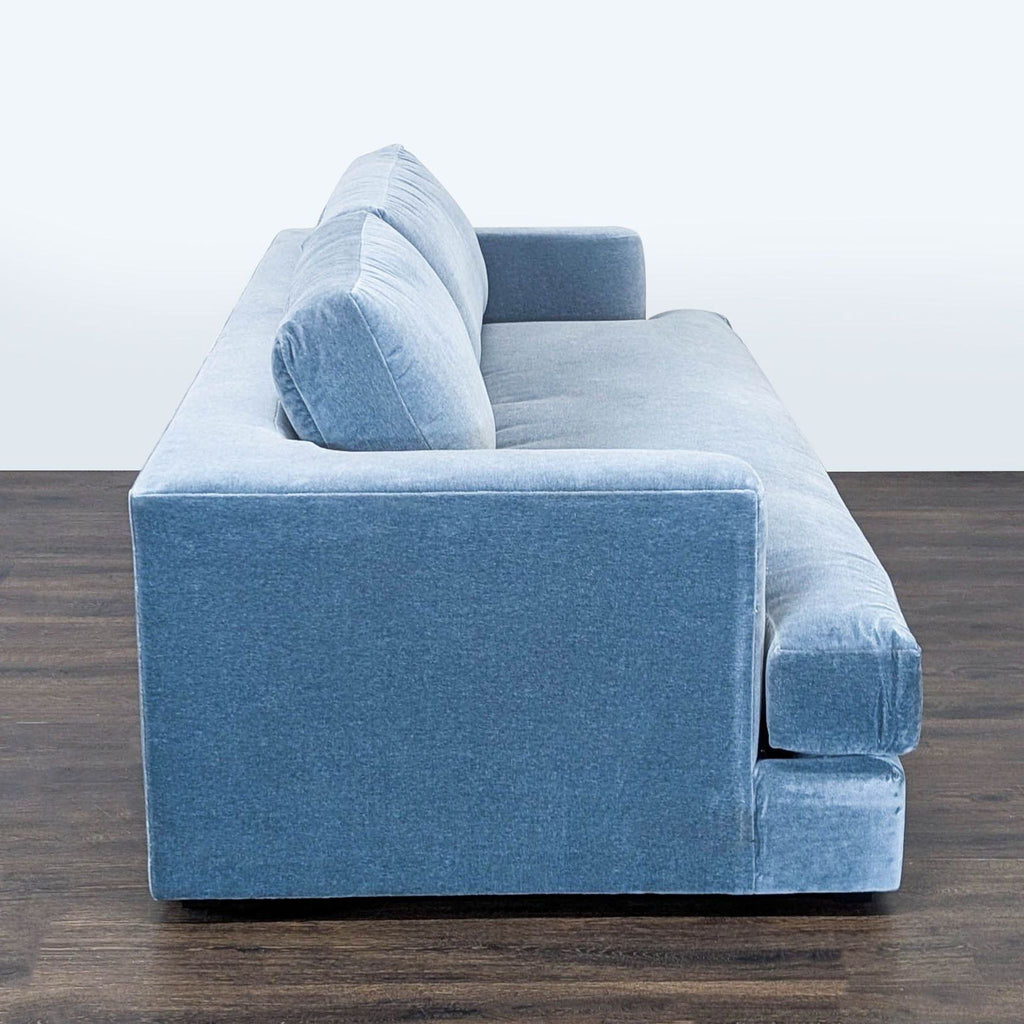 3. Side profile of a Maiden Home 3-seat blue sofa showing thick armrest and cushioned back.