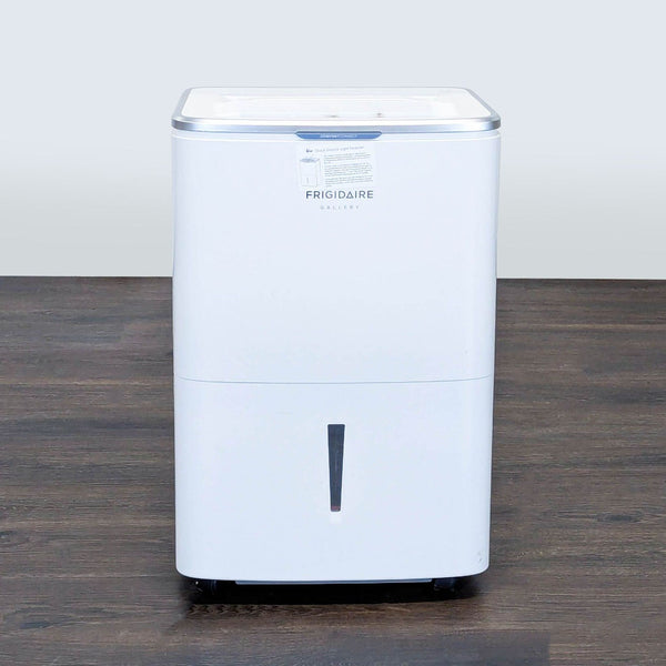 1. Front view of a white Frigidaire dehumidifier from the AC & Fans category, standing on a wooden floor.