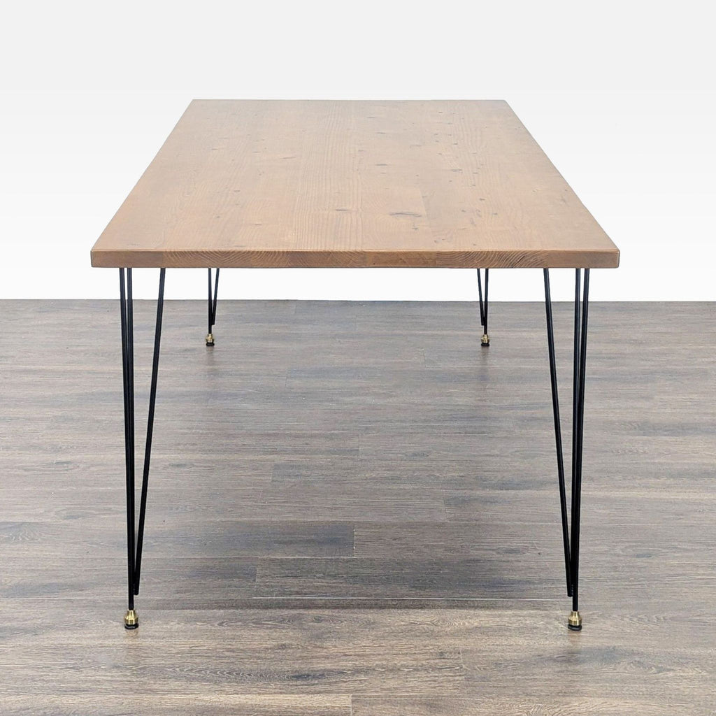 2. Side angle of an Urban Wood Goods dining table featuring a natural wood surface and slim black metal legs.